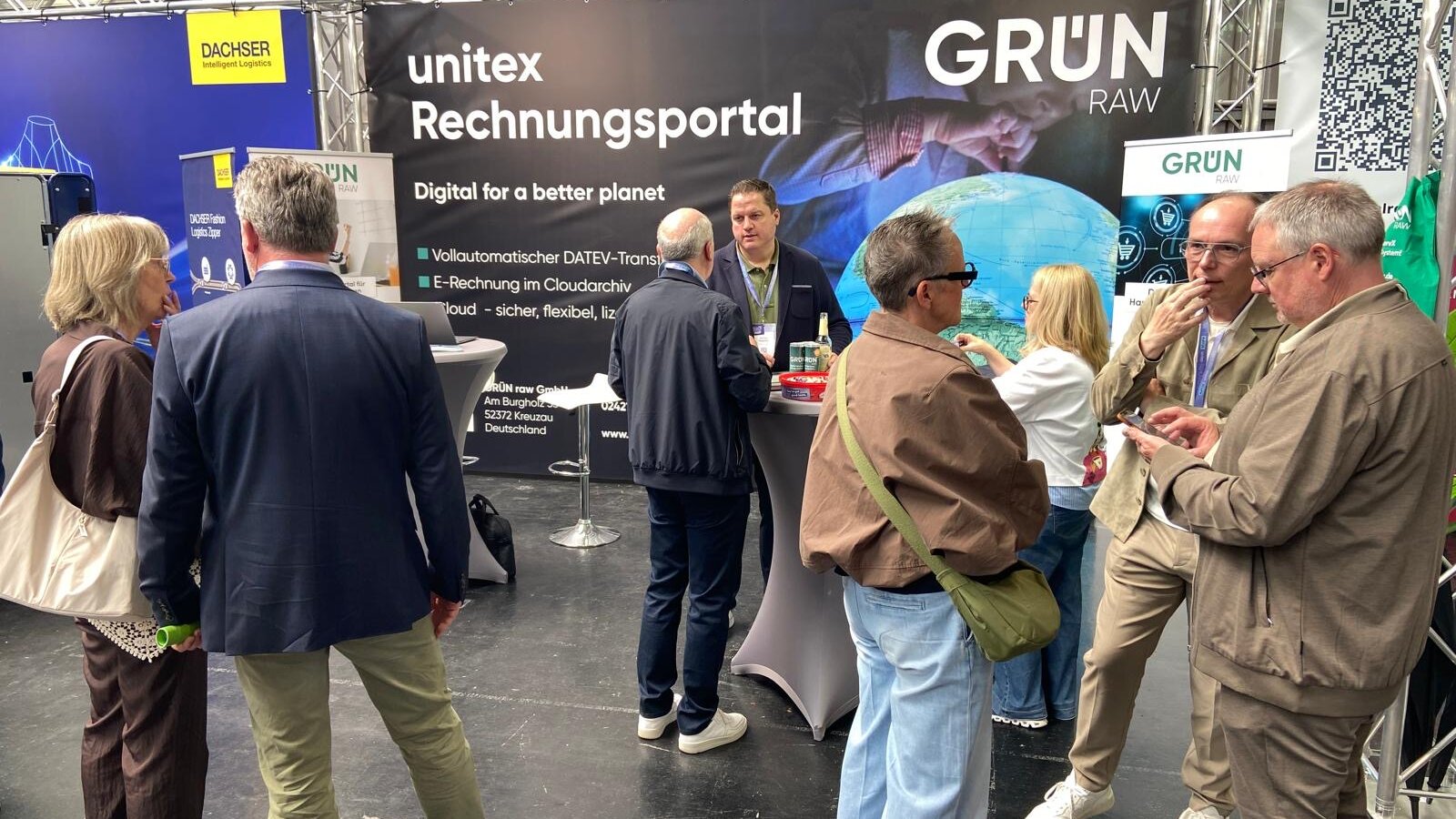 Messestand der GRÜN raw auf dem unitex FASHION FESTIVAL mit Rechnungsportal, Rollups und Stehtischen